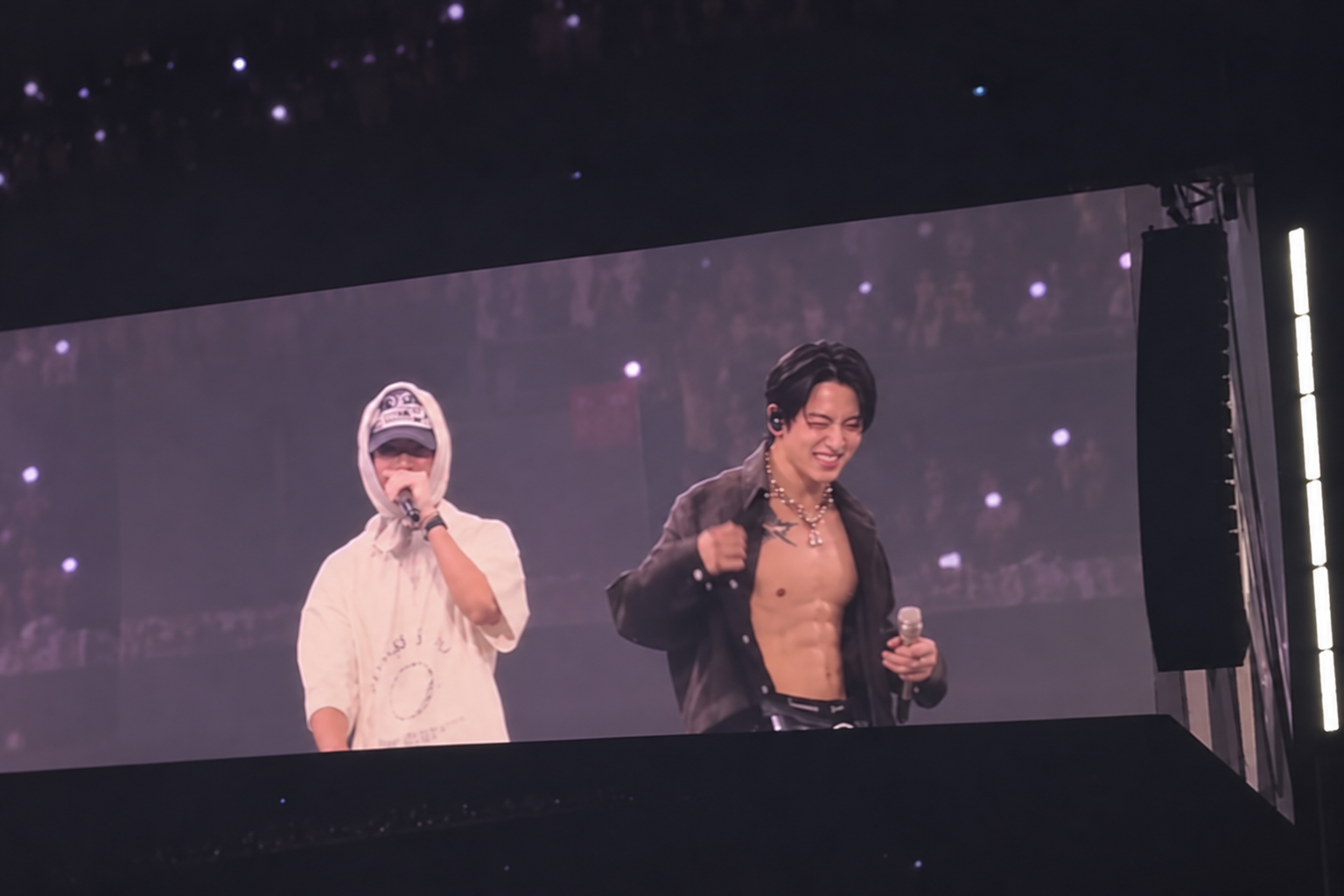 Jungkook i j-hope na velikom ekranu iznad pozornice na SoFi Stadiumu.